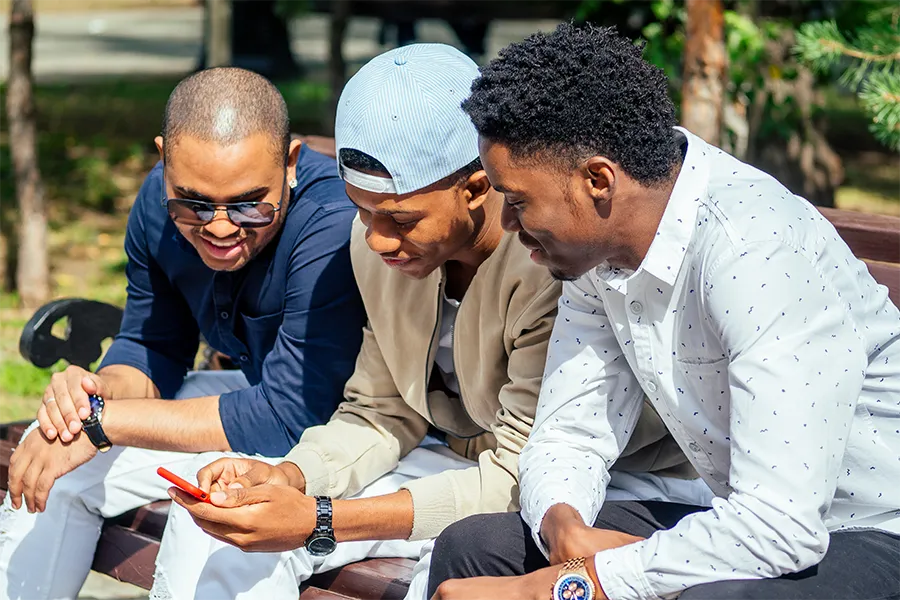Three Black men reviewing documents together outdoors